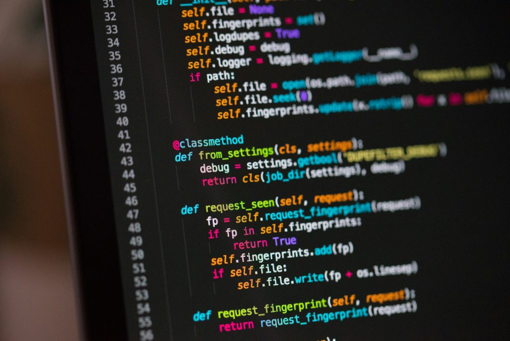 Students working on code at a laptop